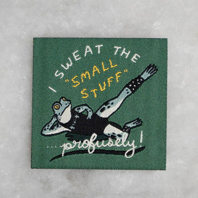 Embroidered patch with a cartoon character and text on a textured surface