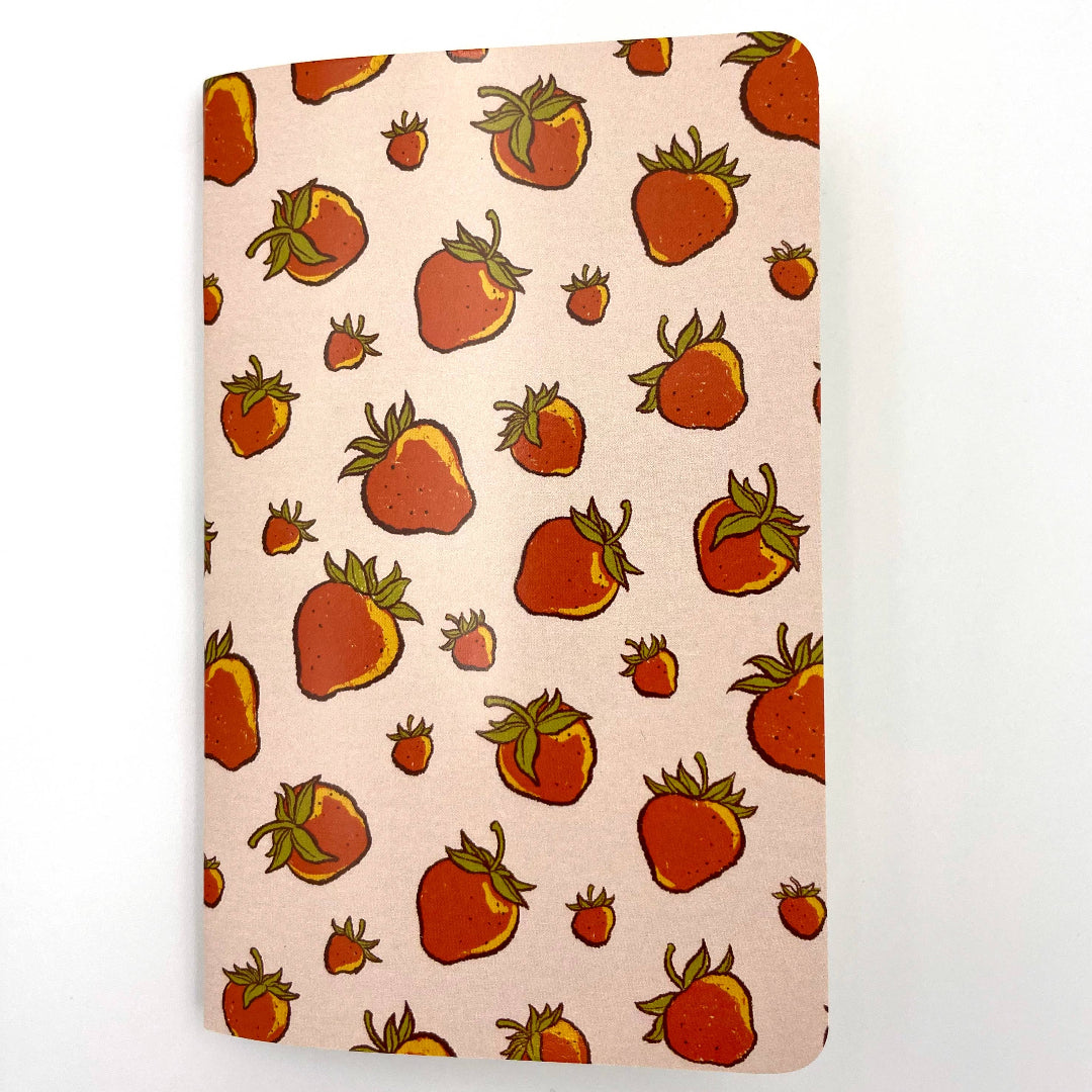 Notebook with strawberry pattern on a light pink background