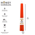 Two orange beeswax candles are standing upright on a white background. They are tied together with a string and have a label that says "HONEY CANDLES 100% Pure Beeswax" and a honeycomb pattern. The label also includes information about the candles, such as the fact that they are made in Canada, family-owned, and handmade in small batches.