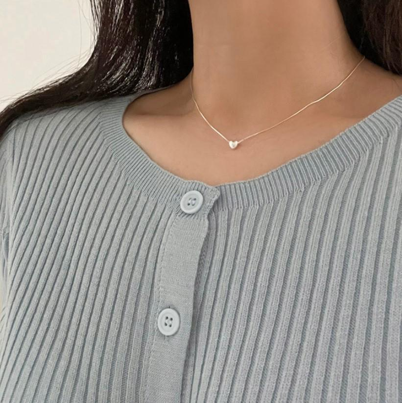 A teeny tiny heart necklace made of polished silver, featuring a very small, solid heart pendant on a delicate chain, displayed on a white background. This minimalist necklace is available in Ottawa, Ontario, Canada.