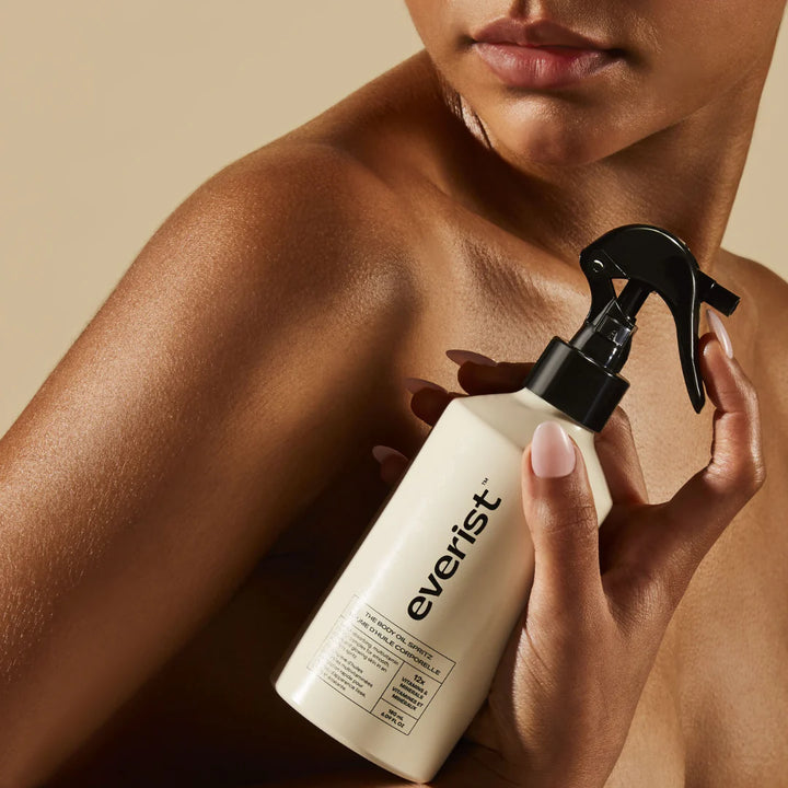 A white bottle with a black label and a spray nozzle. The label reads 