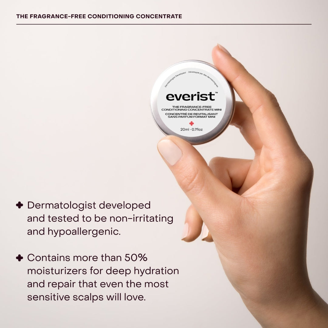 A small, open, silver metal tin of Everist's "The Fragrance-Free Conditioner Concentrate Mini," revealing a translucent, gel-like product inside. The tin's lid is propped against the base, and text on the side indicates it's dermatologist-developed and contains 20ml of product.