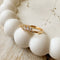 A gold ring with a cluster of small, clear stones set in a curved band.