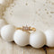 A gold ring with a cluster of small, clear stones set in a curved band.