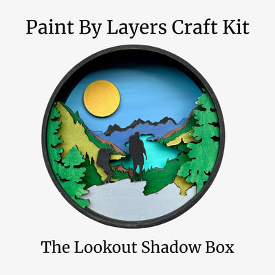 Paint by Layers Craft Kit packaging with a scenic design of hikers and trees.