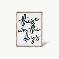 Framed artwork with 'these are the days' text on a white background