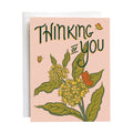 Greeting card with floral design and 'Thinking of You' text on a pink background