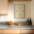 Kitchen counter with a bowl of oranges, a bottle of wine, and a decorative sign on the wall.
