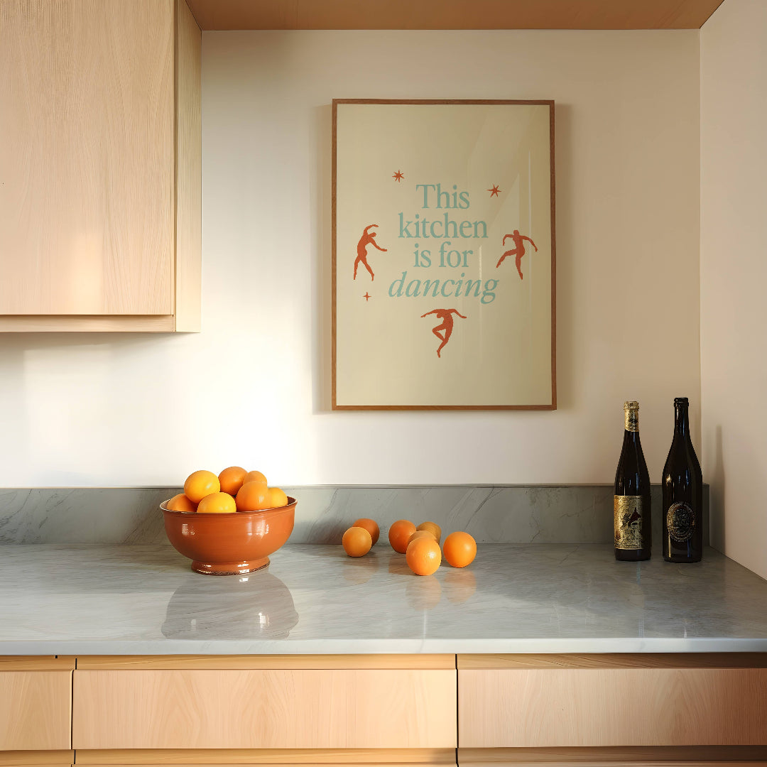 Kitchen counter with a bowl of oranges, a bottle of wine, and a decorative sign on the wall.