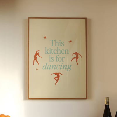Kitchen counter with a bowl of oranges, a bottle of wine, and a framed picture on the wall.