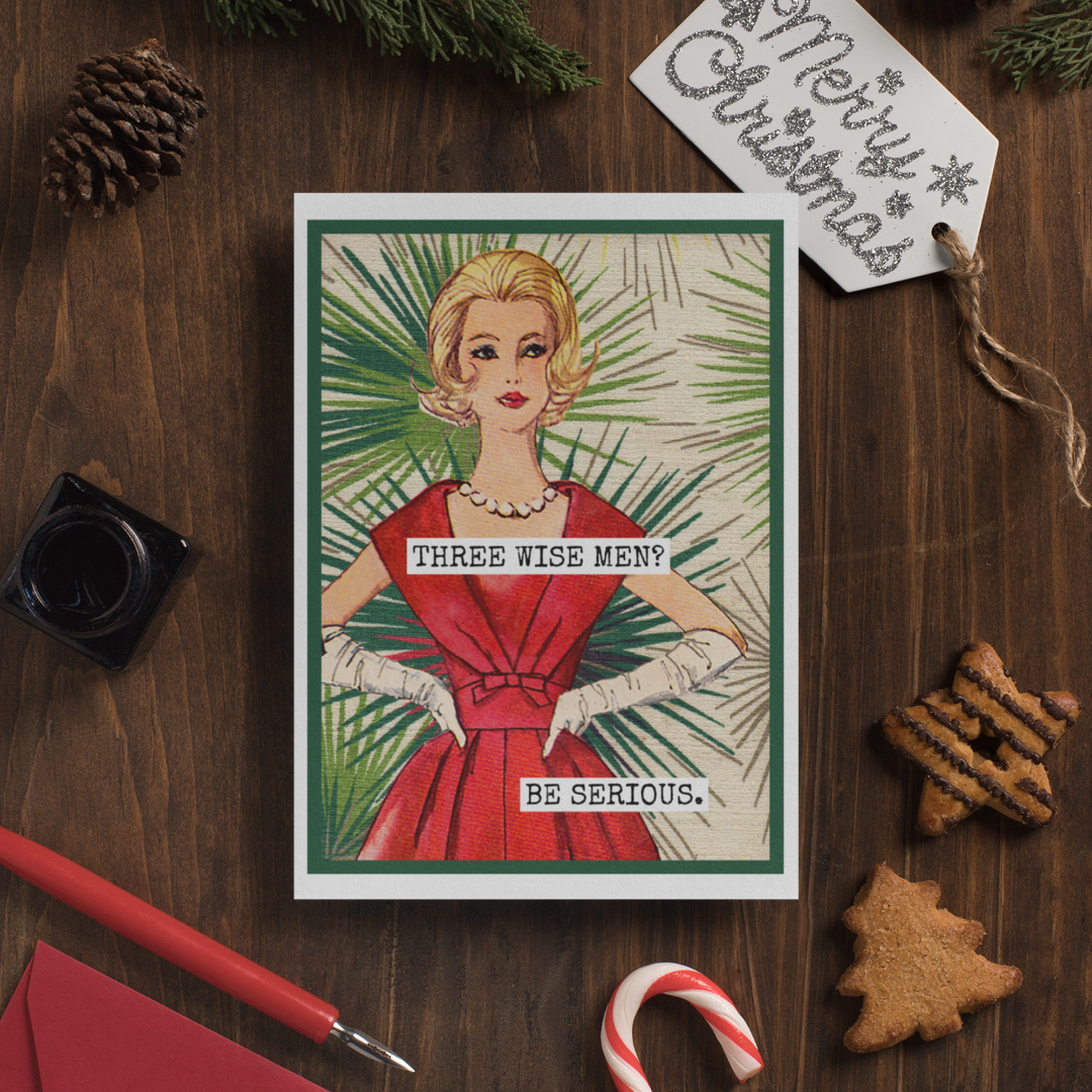 Vintage-style Christmas card with a woman in a red dress on a wooden surface with holiday decorations.