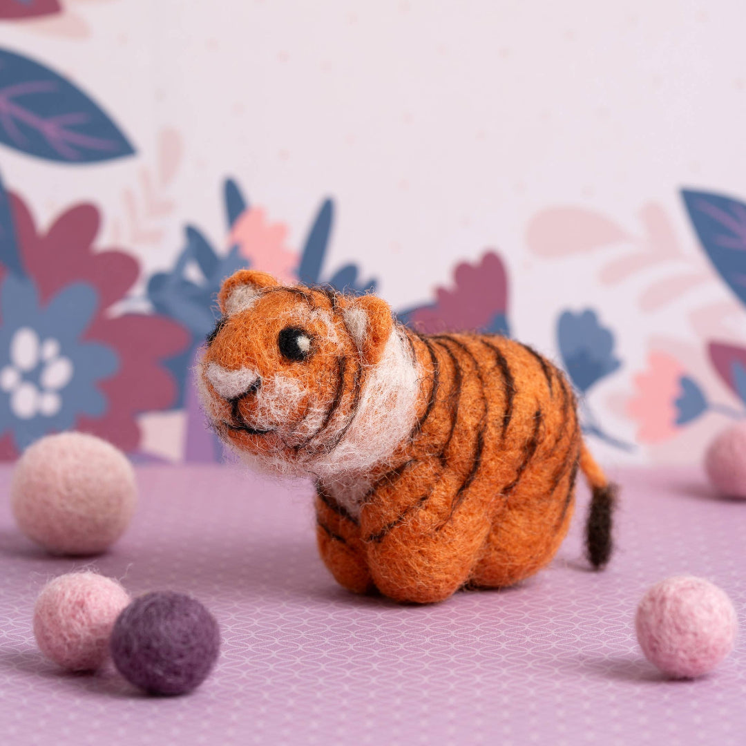 Toy tiger with colorful balls on a floral-patterned background