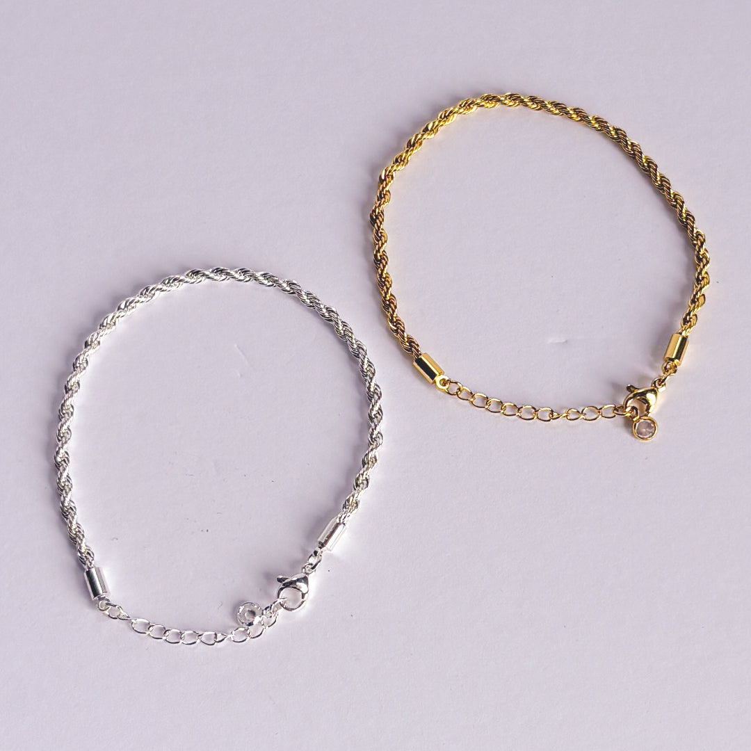 Gold and silver braided bracelets on a light gray background