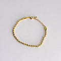 Gold bracelet on a light gray background