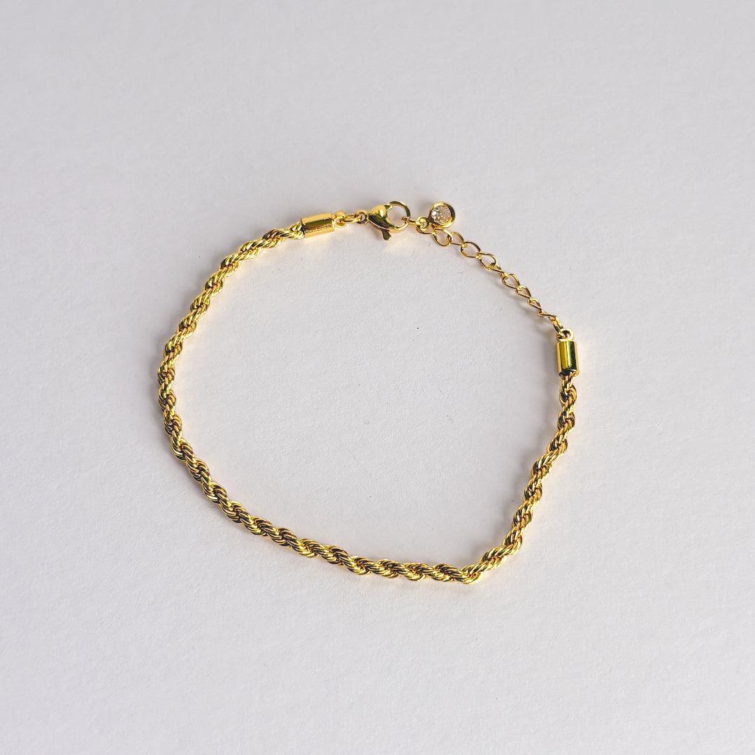 Gold bracelet on a light gray background