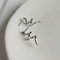 A pair of twisty coil earrings made of sterling silver, featuring a unique, abstract, and wavy design, displayed on a light-colored surface. These modern earrings are available in Ottawa, Ontario, Canada.