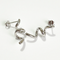 A pair of twisty coil earrings made of sterling silver, featuring a unique, abstract, and wavy design, displayed on a light-colored surface. These modern earrings are available in Ottawa, Ontario, Canada.
