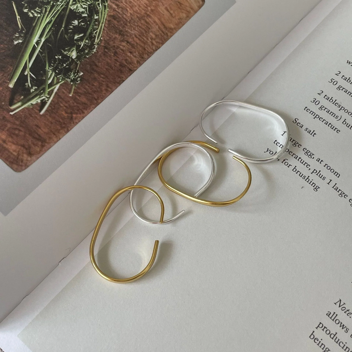 U-shaped open hoop earrings made with 18k gold and sterling silver plating, featuring a modern, minimalist, and open curved design, displayed on a white background. These unique earrings are available in Ottawa, Ontario, Canada.
