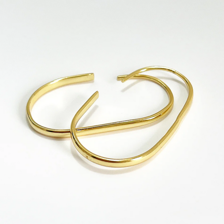 U-shaped open hoop earrings made with 18k gold plating, featuring a modern, minimalist, and open curved design, displayed on a white background. These unique earrings are available in Ottawa, Ontario, Canada.