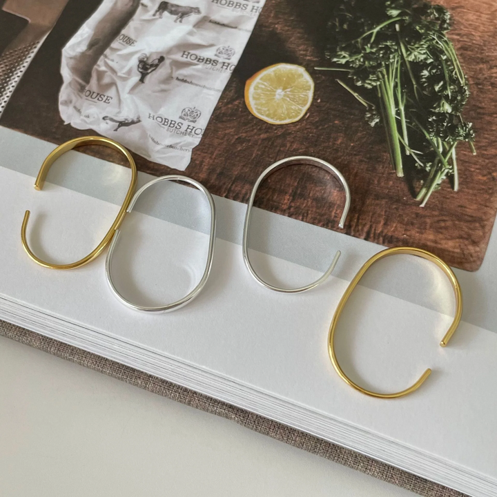 U-shaped open hoop earrings made with 18k gold and sterling silver plating, featuring a modern, minimalist, and open curved design, displayed on a white background. These unique earrings are available in Ottawa, Ontario, Canada.