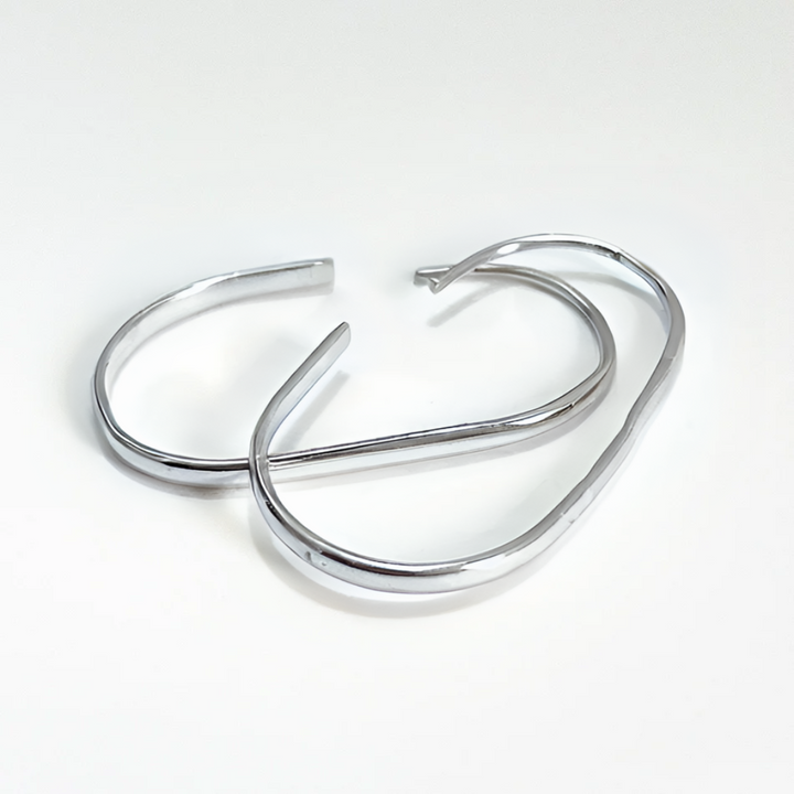 U-shaped open hoop earrings made with Sterling Silver plating, featuring a modern, minimalist, and open curved design, displayed on a white background. These unique earrings are available in Ottawa, Ontario, Canada