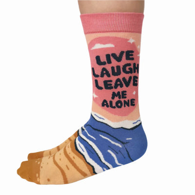 A pair of pink socks with a beach-themed design. The socks feature a beach scene, waves, and the text 