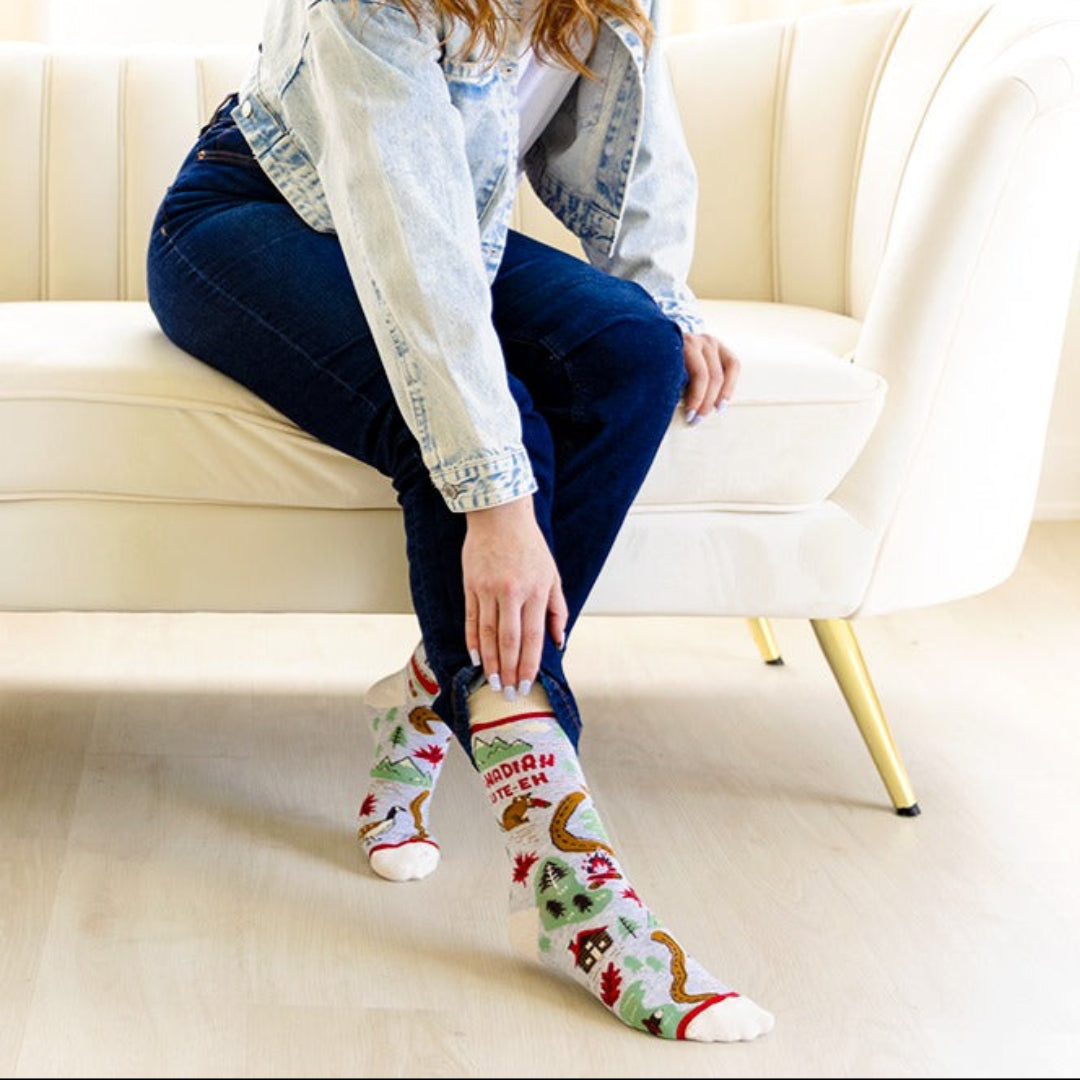 Woman sitting on a couch wearing colorful Christmas-themed socks.