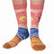A pair of pink socks with a beach-themed design. The socks feature a beach scene, waves, and the text 