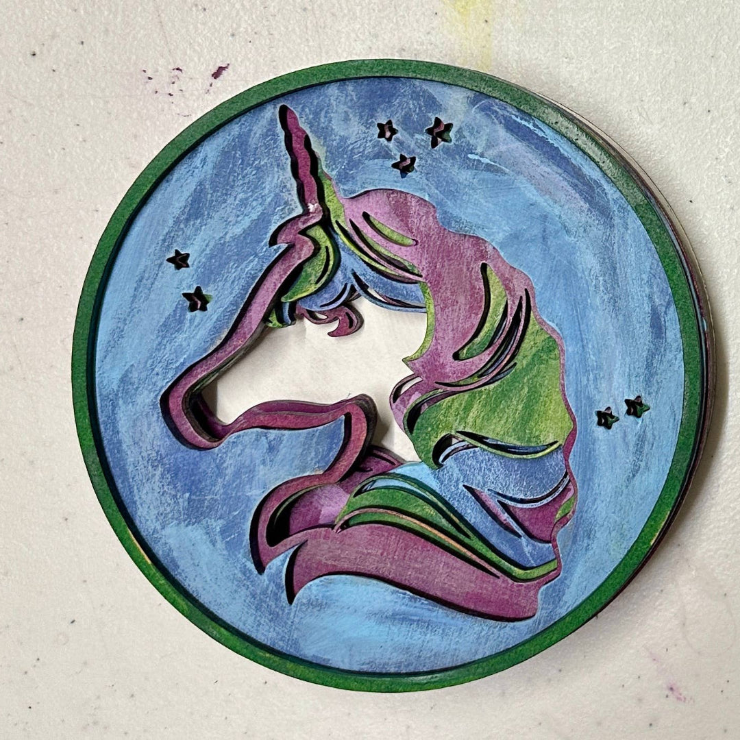 Decorative circular piece with a unicorn design on a textured surface