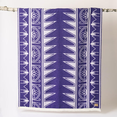 Purple and white patterned towel hanging on a rack against a white background