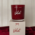 Red candle labeled 'Velvet' by North + Rose on a matching box against a neutral background.