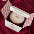 Velvet candle in a decorative box with a red fabric background