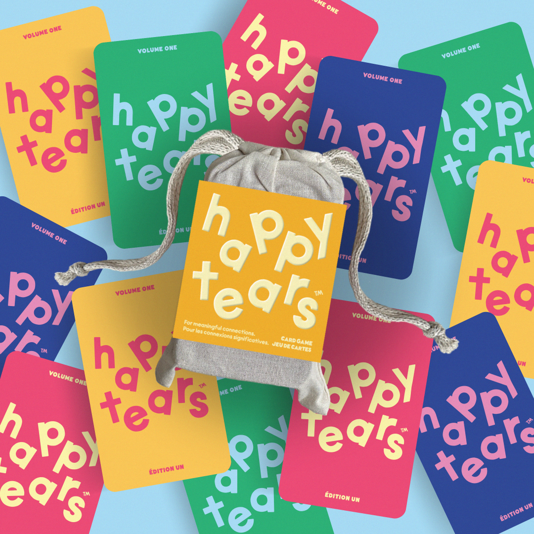 Happy Tears conversation cards, Ottawa. Inclusive card game for meaningful connections. Grey drawstring bag, multicoloured rainbow cards. Fun queer card game.