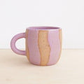 purple and beige ceramic mug on a light background