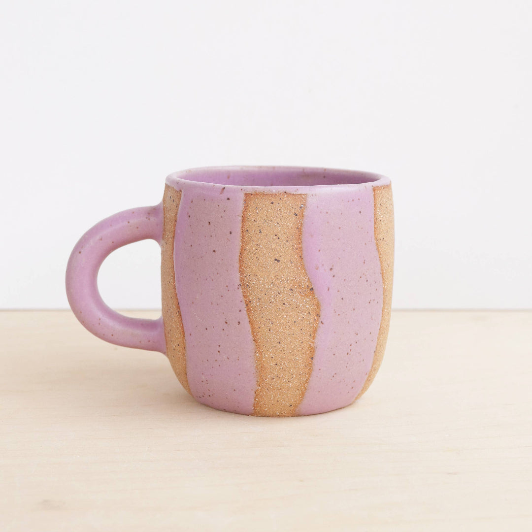 purple and beige ceramic mug on a light background