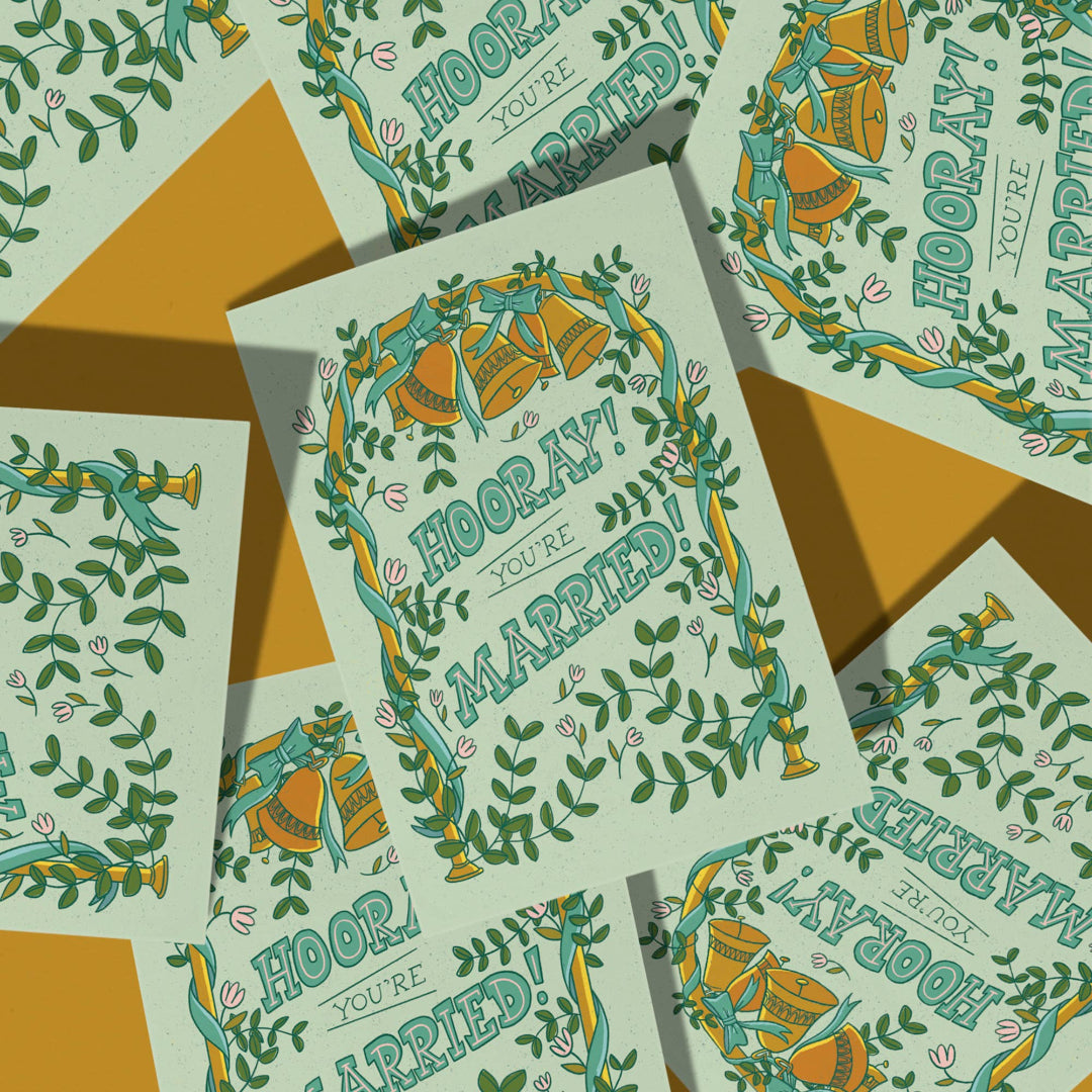 Wedding cards with 'Hooray! You're Married!' text and decorative elements on a patterned background.