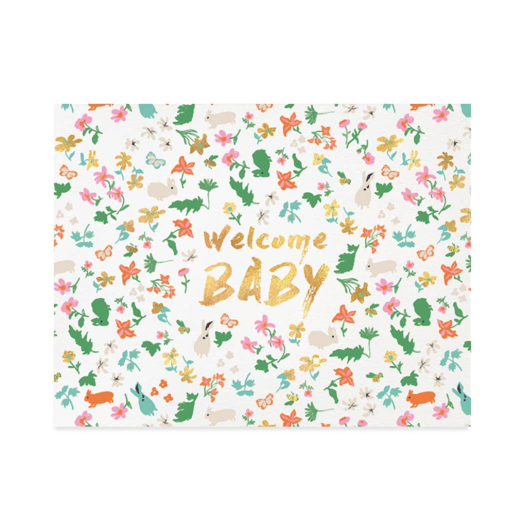 A square baby shower game board or card with a white background covered in a colorful floral and animal pattern, featuring the words 'Welcome BABY' in gold foil-style lettering in the center.