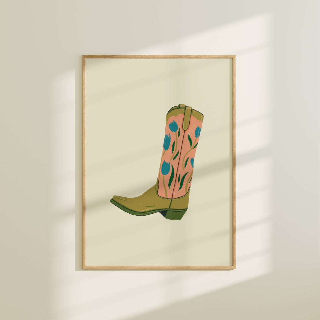 Framed artwork of a pink and green cowboy boot on a light background