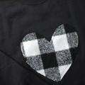 A black sweatshirt with a large, white and black buffalo plaid heart design in the center.