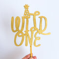 Gold 'Wild One' cake topper on a white background