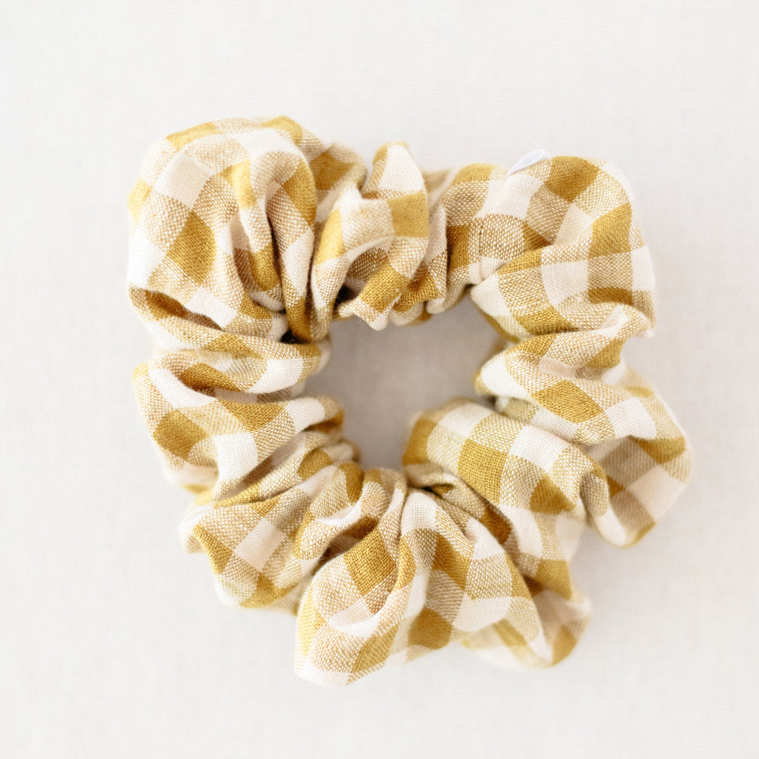 Yellow and white checkered scrunchie on a light gray background
