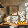 Kitchen counter with lemons, a cutting board, and a framed picture on a tiled wall.