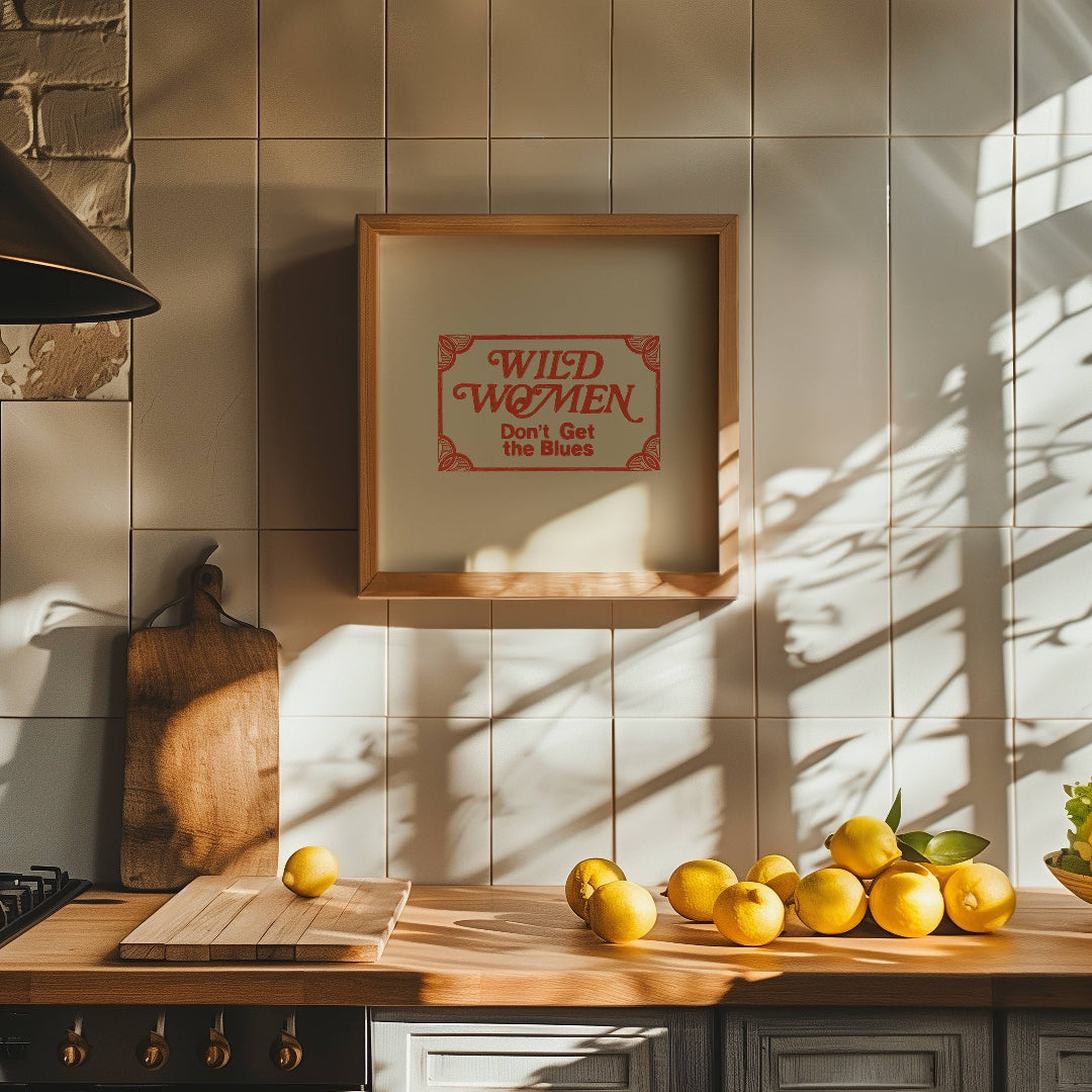 Kitchen counter with lemons, a cutting board, and a framed picture on a tiled wall.