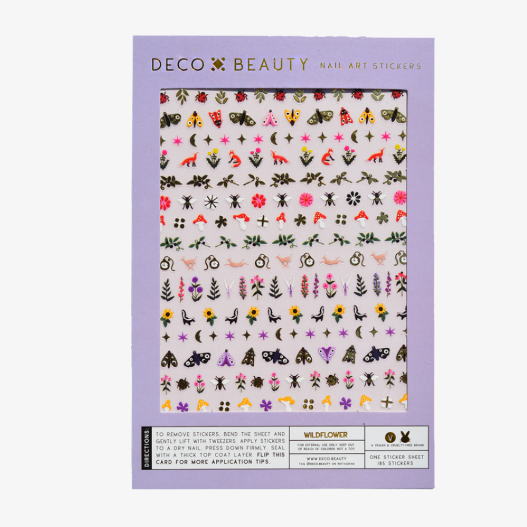 A sheet of colorful nail art stickers with various nature-themed designs. The sheet is purple and has the brand name "Deco Beauty" printed on it. There's a section titled "Wildflower" and instructions on how to apply the stickers. The stickers include designs like flowers, insects, mushrooms, and foxes.