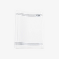 A white, textured exfoliating washcloth with three black stripes along the top edge. The washcloth has a tag with the word "WILDPIER" on it.