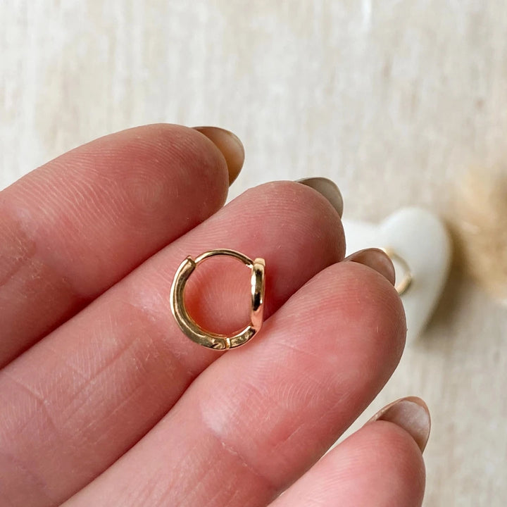 A pair of gold-plated hoop earrings shaped like hearts.