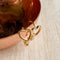 A pair of gold-plated hoop earrings shaped like hearts.