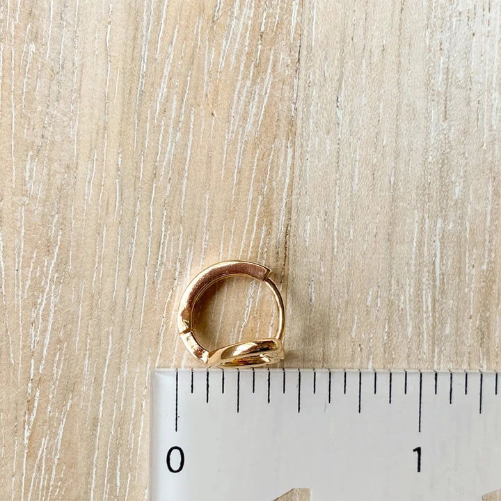 A pair of gold-plated hoop earrings shaped like hearts.