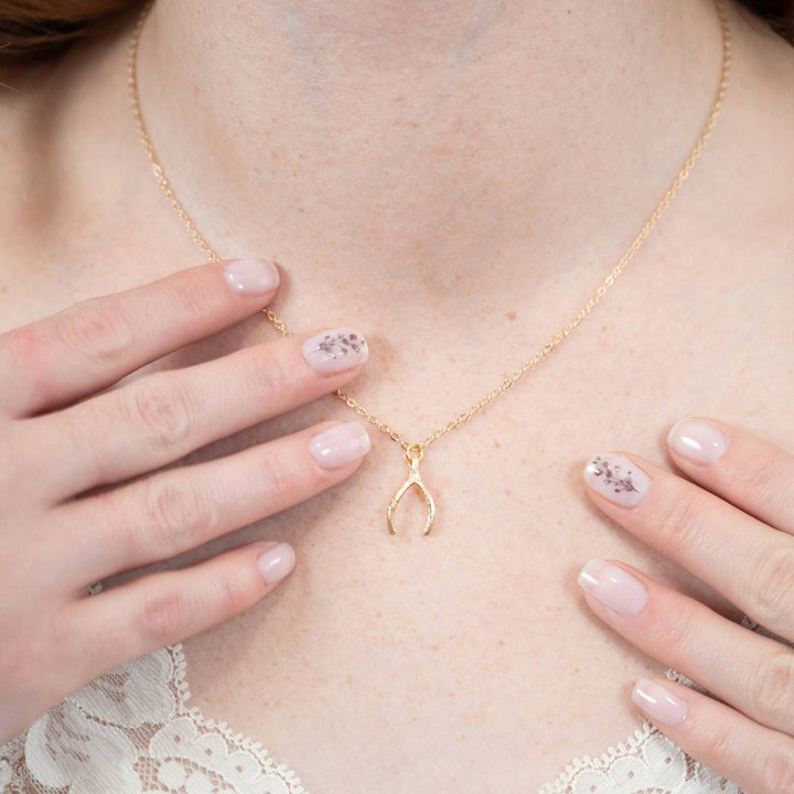 a gold wishbone pendant, with a delicate chain.