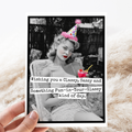 Vintage-style card with a black and white photo of a woman wearing a party hat, held on a textured surface.